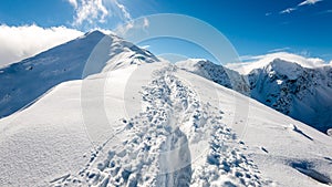 Mountain tops in winter covered in snow with bright sun and blue