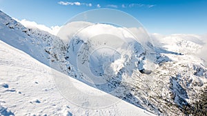 Vrcholy hôr v zime pokryté snehom s jasným slnkom a modrou