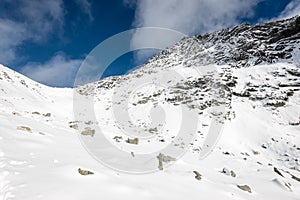 Mountain tops in winter covered in snow with bright sun and blue