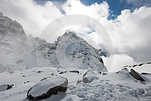 Mountain tops in winter covered in snow with bright sun and blue