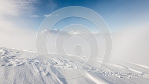 Mountain tops in winter covered in snow with bright sun and blue