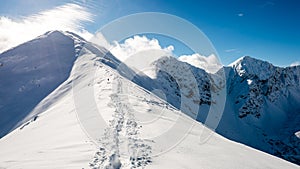 Mountain tops in winter covered in snow with bright sun and blue