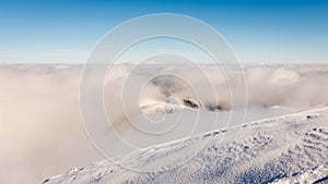 Mountain tops in winter covered in snow with bright sun and blue