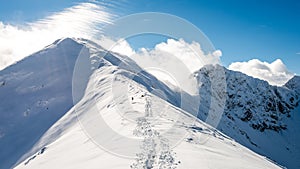 Horské vrcholy v zimě pokryté sněhem s jasným sluncem a modrou