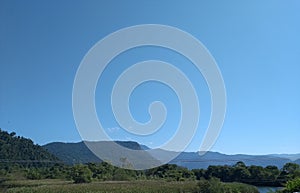 Mountain with trees and the blue sky. photo