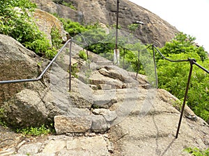Mountain trek with stone steps and iron railings which leads to the top