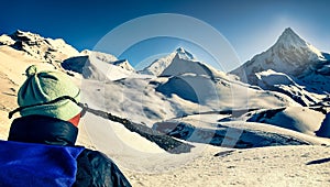 Mountain trekker in high snowed mountains looking in the distance, Himalayas