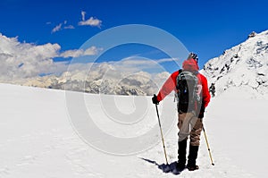 Mountain trekker looking at high winter Himalayas mountains photo