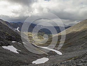 Mountain valley with mosses and rocks covered with lichens. Cloudy sky before storm. Khibiny mountains above the Arctic