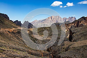 Mountain and valley view along Wadi Sahtan road and snake canyon in Al Hajir mountains between Nizwa and Mascat in Oman photo