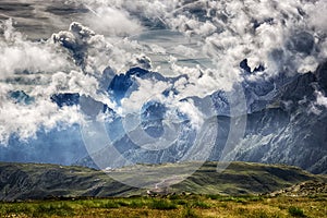 Mountain view with clouds and green fields