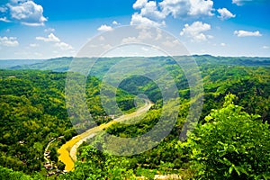 Mountain view of lush green forest and yellow river in East Asia