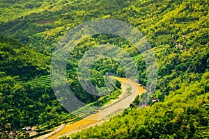 Mountain view of lush green forest and yellow river in East Asia