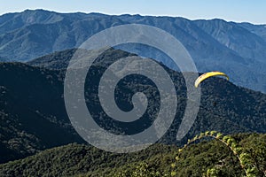 Mountain view with paraglidding and forest under a blue sky photo