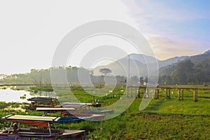 mountain view and rows of fishing boats by the lake in the morning