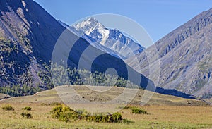 Mountain view, sunny day. Snow-capped peaks, gorge.