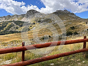 Mountain view. Wooden fence and the meadow on foothills