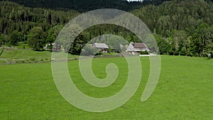 Mountain village in European Alps surrounded with green meadows and pastures