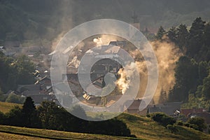 Mountain village in the valley suffocating with smoke and smog from wood and coal-fired stoves