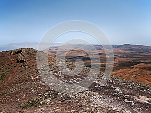 Mountain volcanic hillsides with rare plants on the background of deep blue sky with white clouds. Lanzarote photo