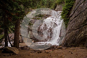 A mountain waterfall of coniferous forest and the slopes of the Rocky Mountains. Tourism concept, eco recreation, Alberta, Canada