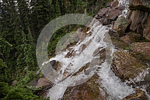 A mountain waterfall of coniferous forest and the slopes of the Rocky Mountains. Tourism concept, eco recreation, Alberta, Canada