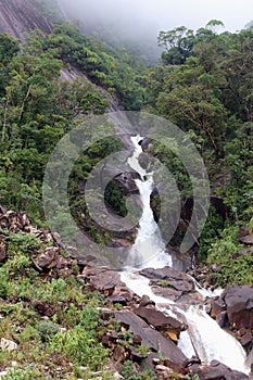 Mountain waterfall flowing out of the fog