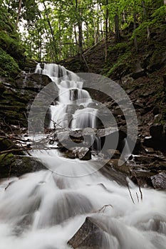 Mountain waterfall in the green forest.
