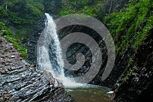 Mountain waterfall, large water flow of mountain waterfall, mountain river near the rock. Huk Waterfall, Ukrainian