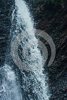 Mountain waterfall, large water flow of mountain waterfall, mountain river near the rock. Huk Waterfall, Ukrainian