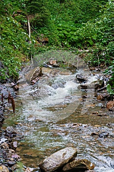 Mountain waterfall, large water flow of mountain waterfall, mountain river near the rock. Huk Waterfall, Ukrainian