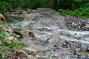 Mountain waterfall, large water flow of mountain waterfall, mountain river near the rock. Huk Waterfall, Ukrainian