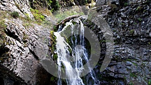 A mountain waterfall in a rocky gorge.