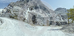 Mountain white road climbing at white marble quarry, Carrara, Italy