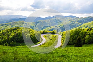 Horská klikatá silnice na Slovensku, pohled shora s výhledem na hory