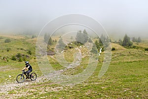 Mountainbike descending out of the fog