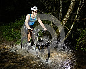 Mountainbiker driving through a streambed