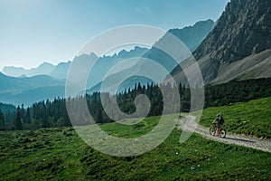 Mountainbiking in the Karwendel mountains in front of blue mountain layers, Austria