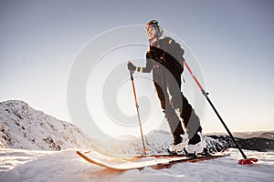 Mountaineer backcountry ski walking in the mountains. Ski touring in high alpine landscape. Adventure winter extreme sport. Sunny