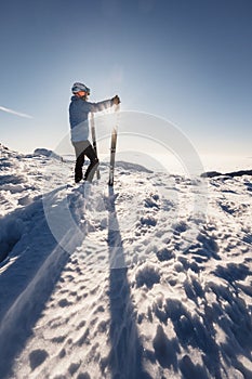Mountaineer backcountry ski walking in the mountains. Ski touring in high alpine landscape. Adventure winter extreme sport. Sunny