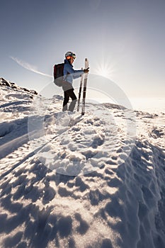 Mountaineer backcountry ski walking in the mountains. Ski touring in high alpine landscape. Adventure winter extreme sport. Sunny