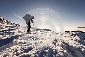 Mountaineer backcountry ski walking in the mountains. Ski touring in high alpine landscape. Adventure winter extreme sport. Sunny