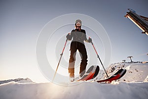 Mountaineer backcountry ski walking in the mountains. Ski touring in high alpine landscape. Adventure winter extreme sport. Sunny