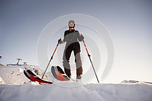 Mountaineer backcountry ski walking in the mountains. Ski touring in high alpine landscape. Adventure winter extreme sport. Sunny