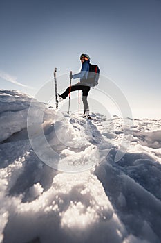 Mountaineer backcountry ski walking in the mountains. Ski touring in high alpine landscape. Adventure winter extreme sport. Sunny