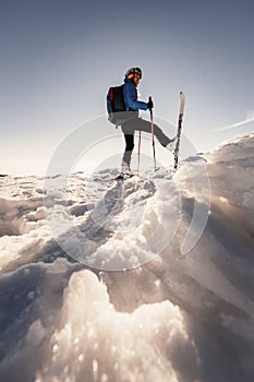 Mountaineer backcountry ski walking in the mountains. Ski touring in high alpine landscape. Adventure winter extreme sport. Sunny