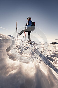 Mountaineer backcountry ski walking in the mountains. Ski touring in high alpine landscape. Adventure winter extreme sport. Sunny