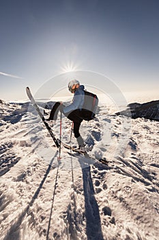 Mountaineer backcountry ski walking in the mountains. Ski touring in high alpine landscape. Adventure winter extreme sport. Sunny