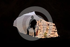MOUNTAINEER IN A CAVE SITUATED ON THE VERTICAL WALL OF A ROCK MOUNTAIN