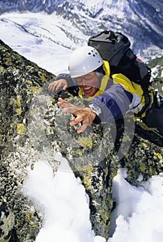 Mountaineer climbing snowy rock face photo